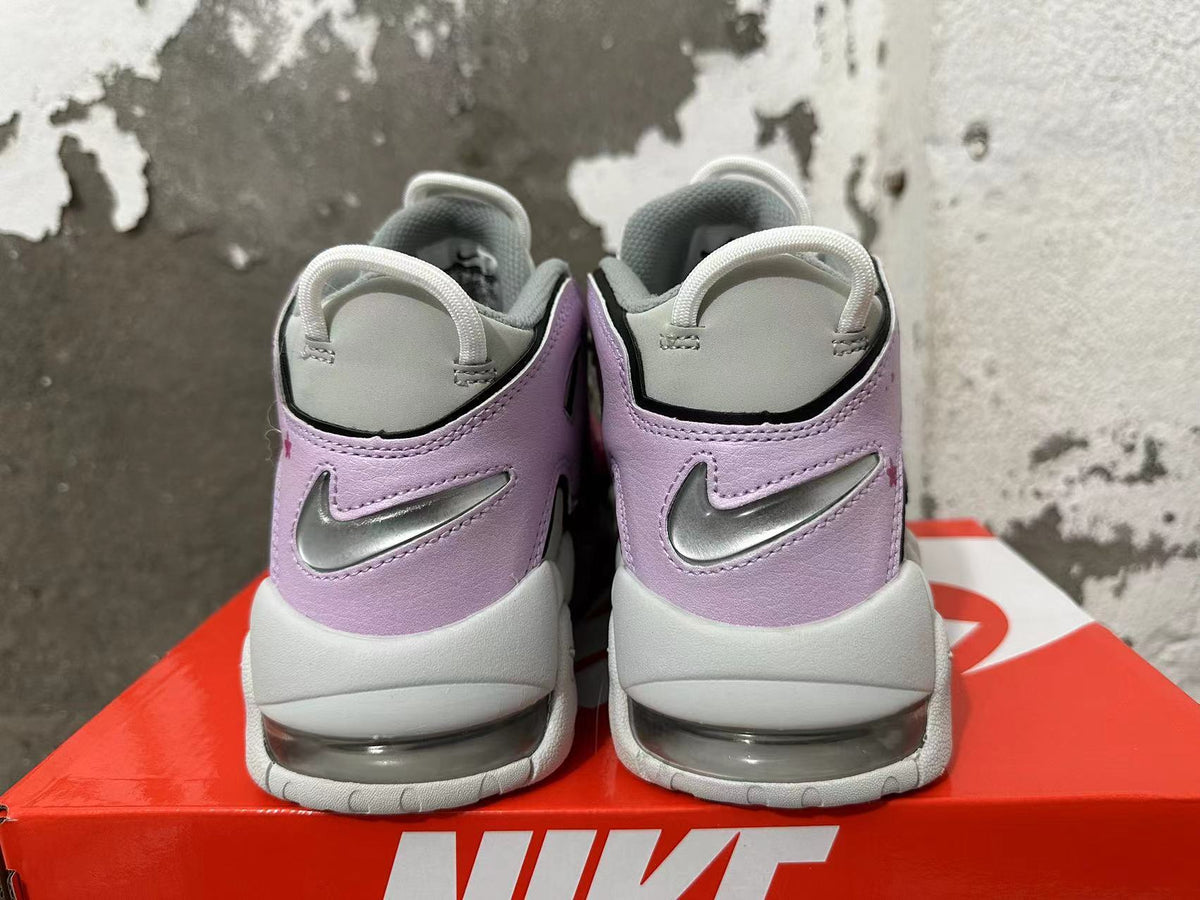 Rear view of gray and lavender Nike sneakers with silver swooshes and visible heel cushioning.