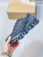 Side profile of the dark gray sneaker showing the textured upper, On logo, lace closure, and hollow outsole sections.