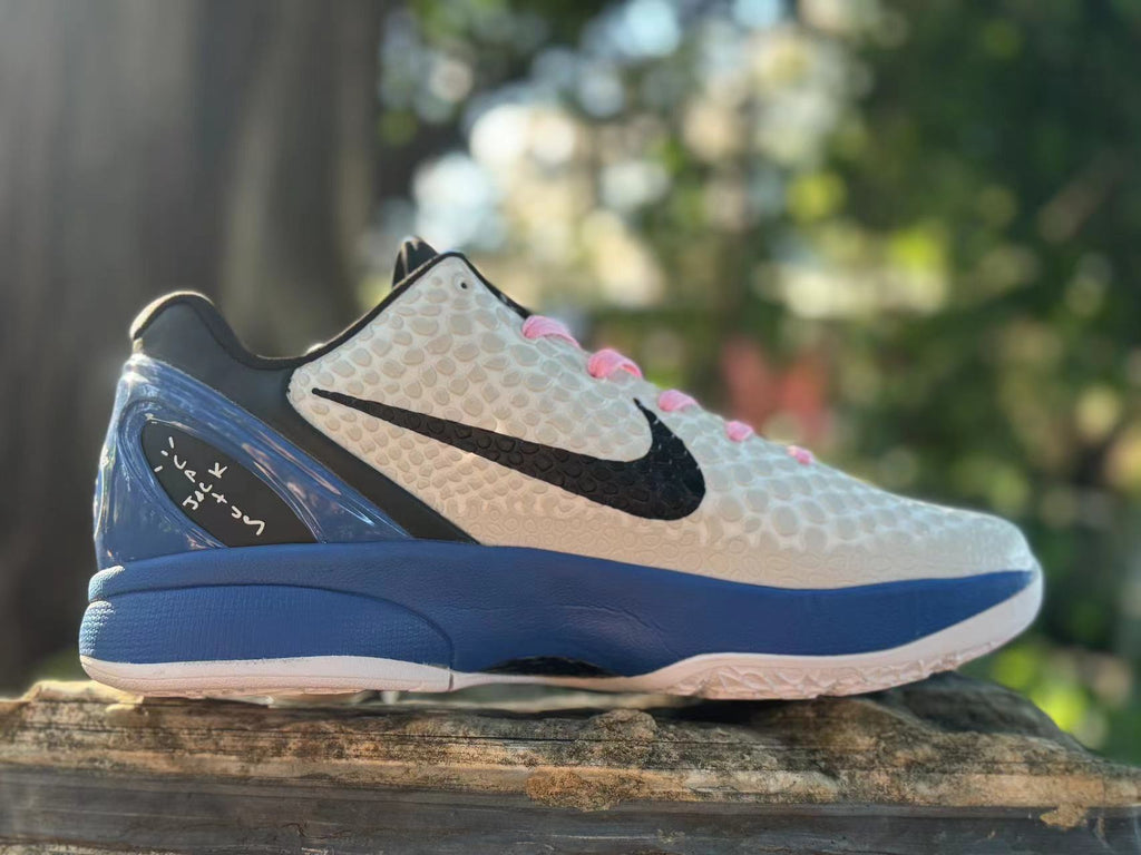 Opposite side view highlighting the black Swoosh and blue heel structure on the white Kobe 6.