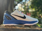 Opposite side view highlighting the black Swoosh and blue heel structure on the white Kobe 6.