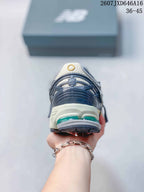 Rear view of a New Balance 1906A sneaker showing the layered heel structure and green cushioning elements.