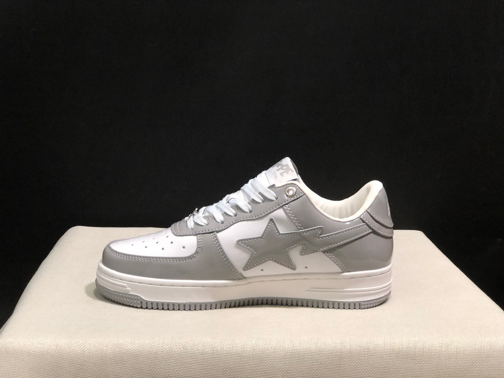 Full side profile of a white and grey low-top sneaker with a star-shaped side logo.