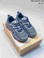Pair of gray ASICS GEL-NYC sneakers displayed on an ASICS shoebox.