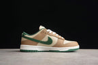 Side profile showing the brown and cream low-top upper, green Swoosh, white midsole, and green outsole.