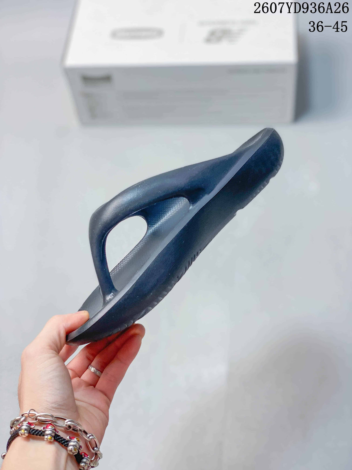 Side view of the black flip-flop sandal showing the raised thong-style upper and sole thickness.