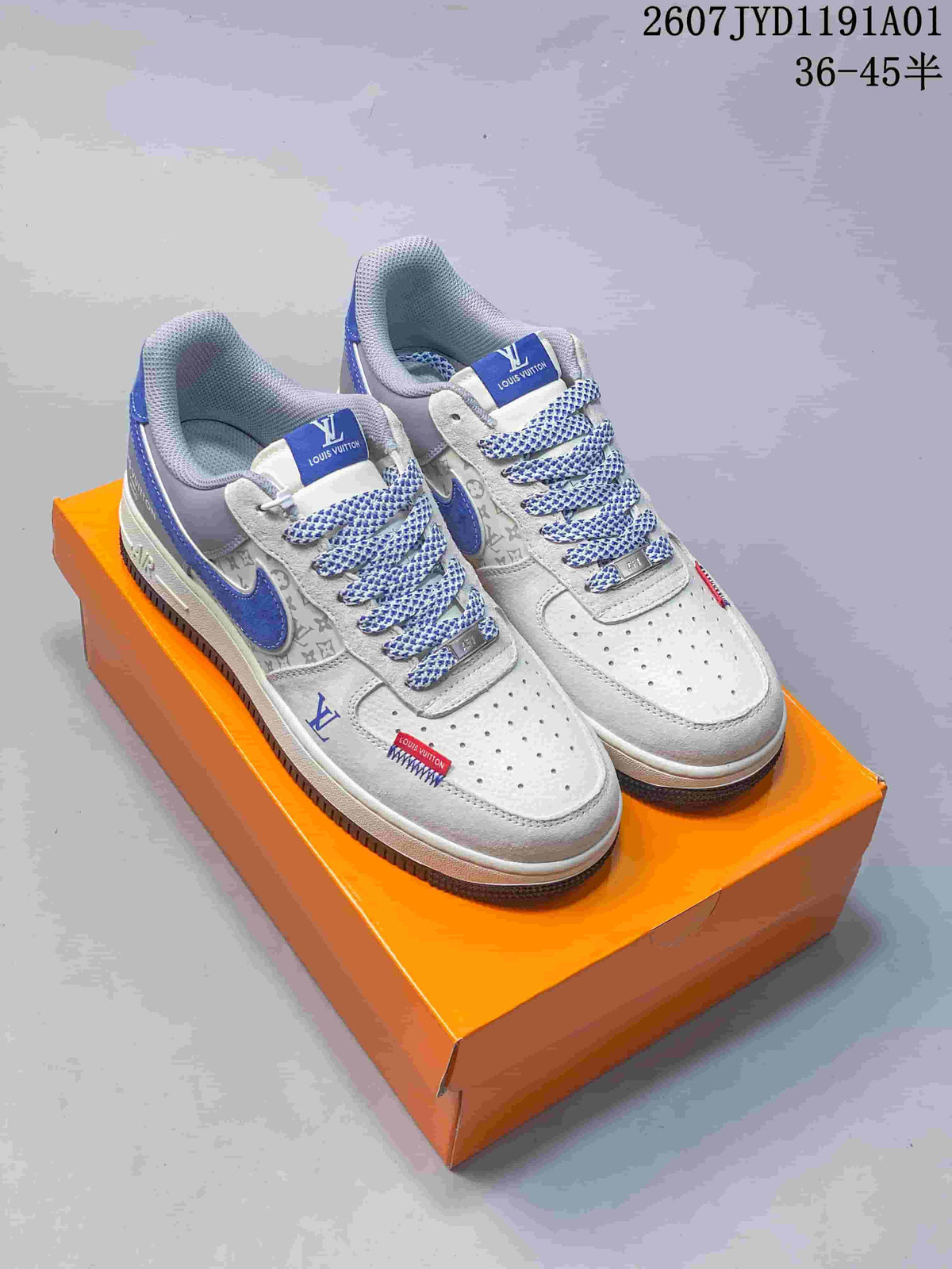 Pair of low-top sneakers with blue accents, gray patterned panels and patterned laces on an orange box.