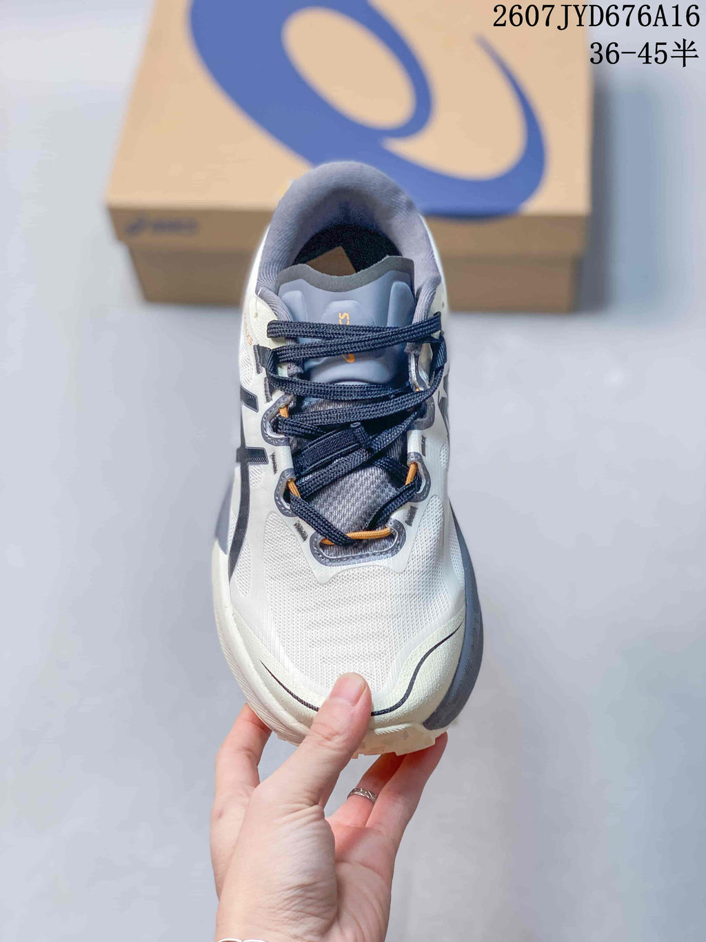 Top view showing the white toe box, dark laces, gray tongue, and orange lace details.