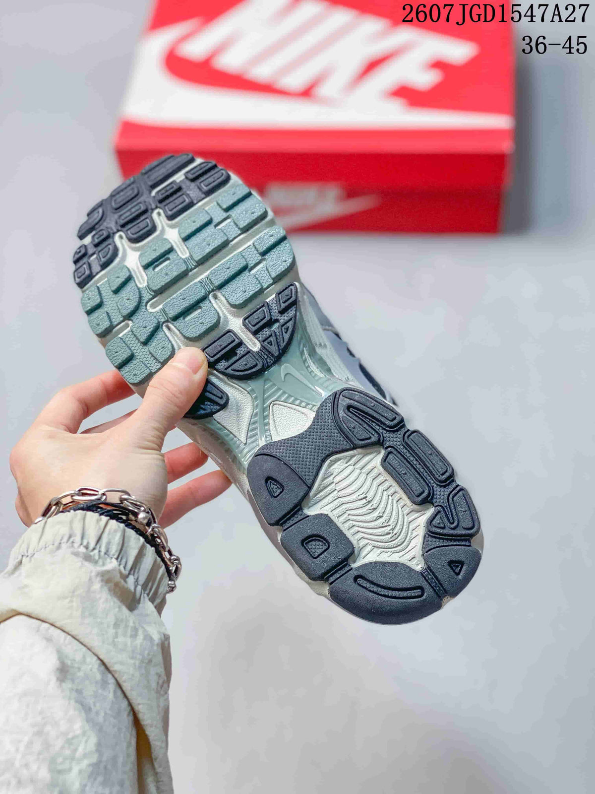 Close view of the sneaker outsole showing segmented dark and green-grey tread sections.