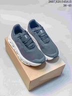 Pair of dark gray and white On CloudTilt sneakers displayed on a cardboard box; image text shows style code 2607JGD1545A15 and sizes 36–45.