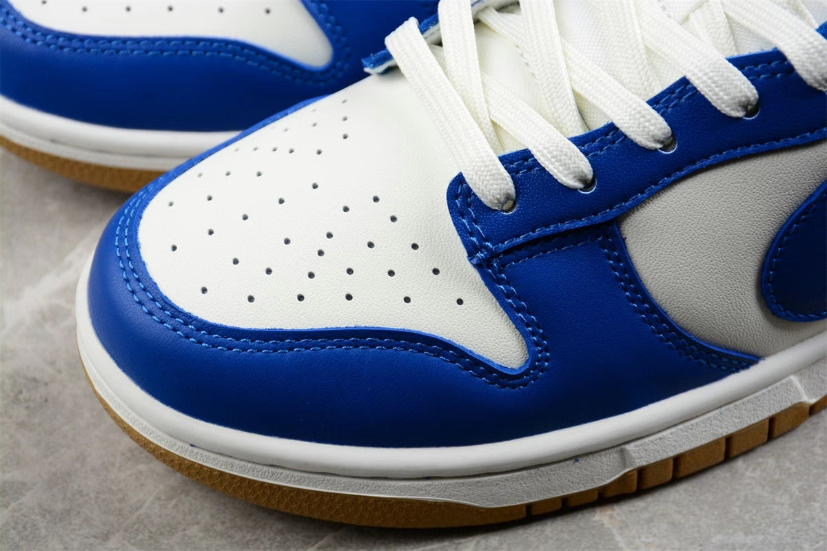 Close-up of the white perforated toe box, blue toe overlay, white midsole, and gum-colored outsole.