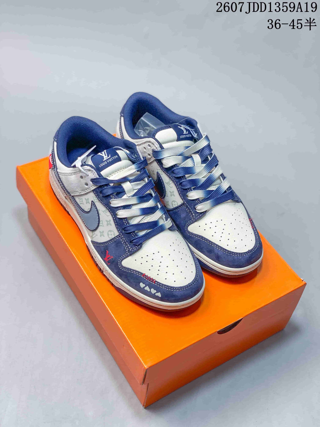 Pair of white and navy low-top sneakers displayed on an orange shoe box, with a visible overlay reading 2607JDD1359A19 and 36–45.5.