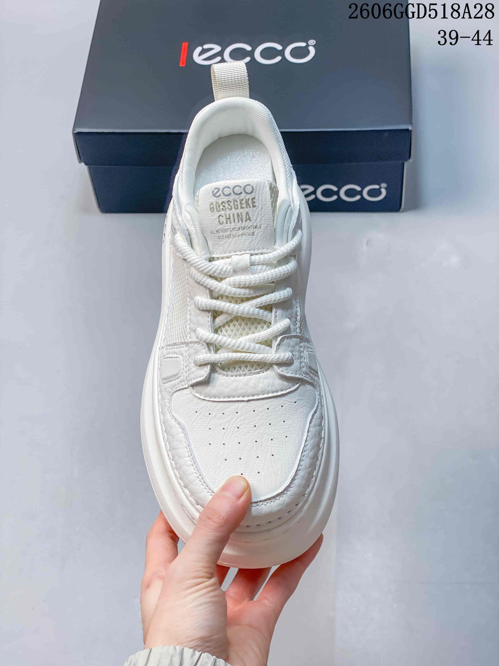 Top view of the white sneaker showing its laces, perforated toe, and mesh tongue area.