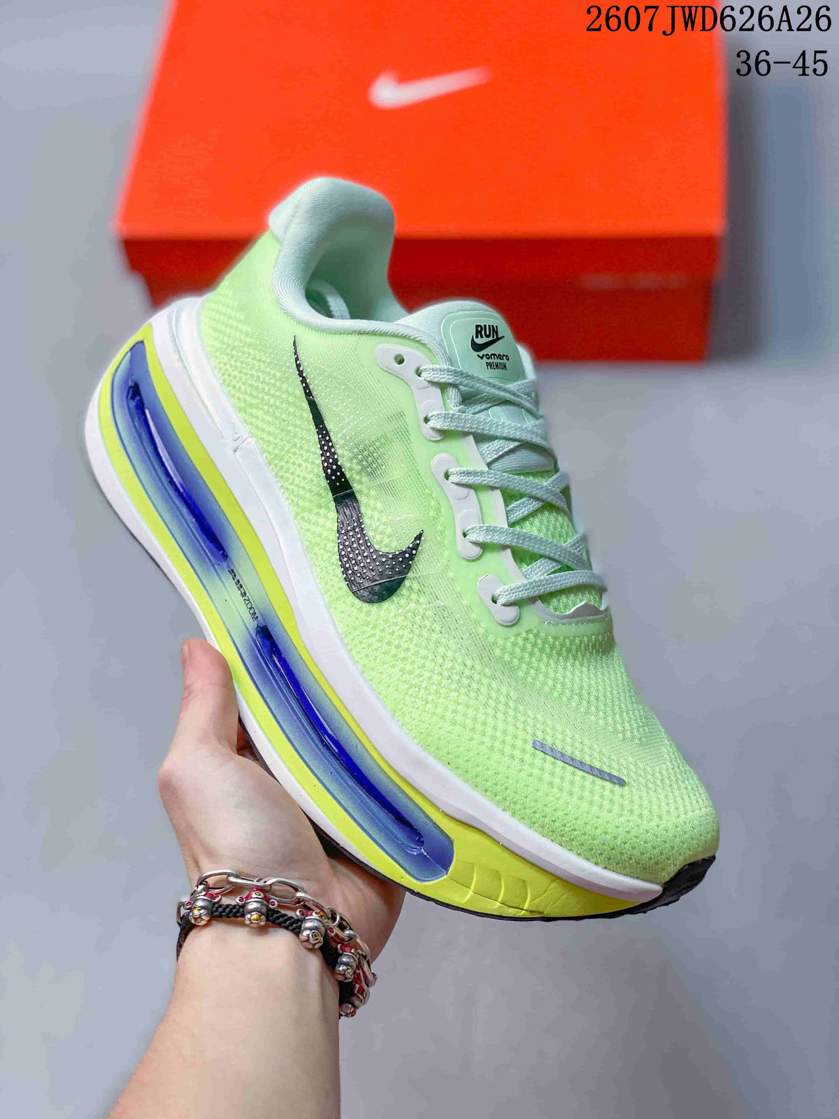 Angled side view of a green Nike sneaker showing the black Swoosh, laces, and layered white, blue, and yellow sole.