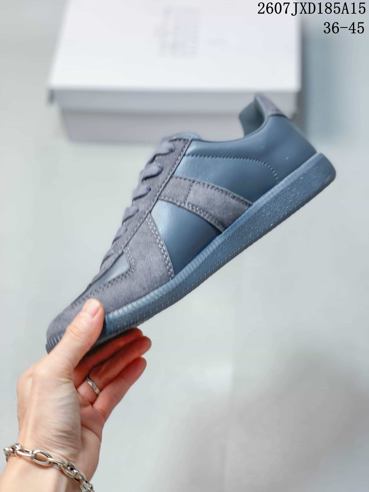 Side profile of the gray low-top sneaker showing layered textured panels, tonal upper sections, and the flat rubber outsole.