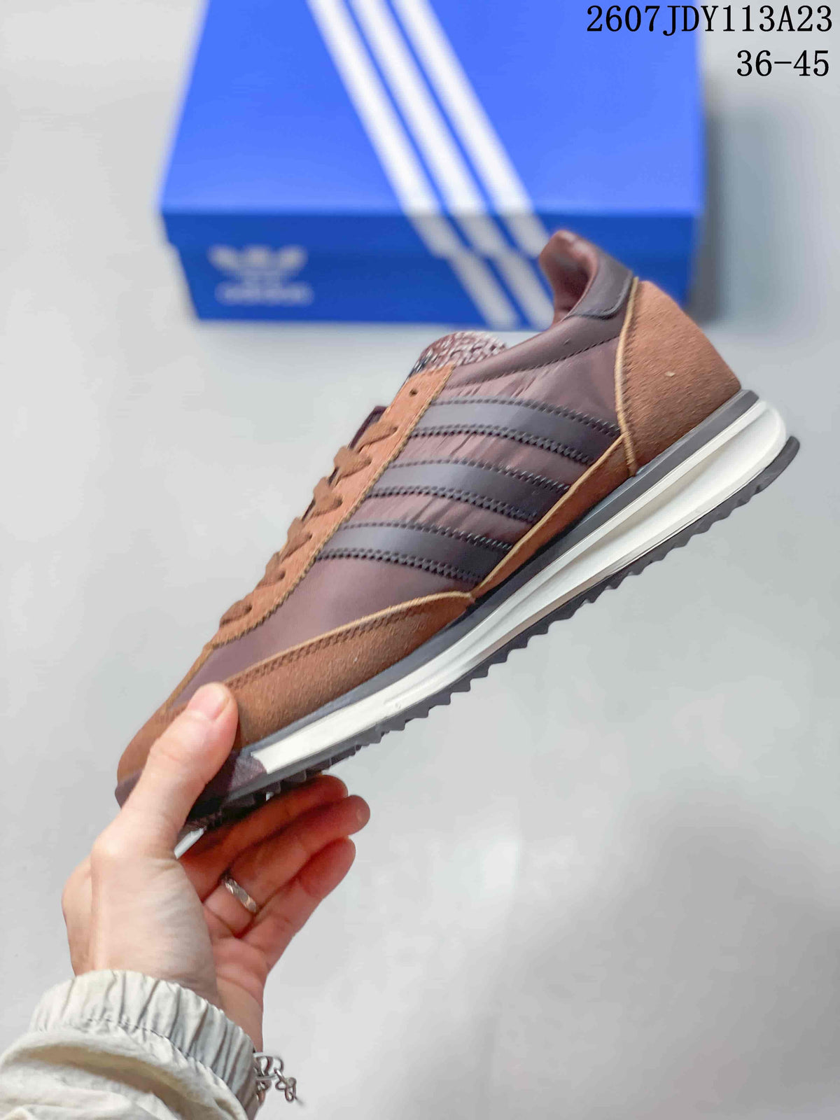 Side profile of the brown adidas SL 72 sneaker showing the three stripes, layered upper panels, white midsole, and dark outsole.