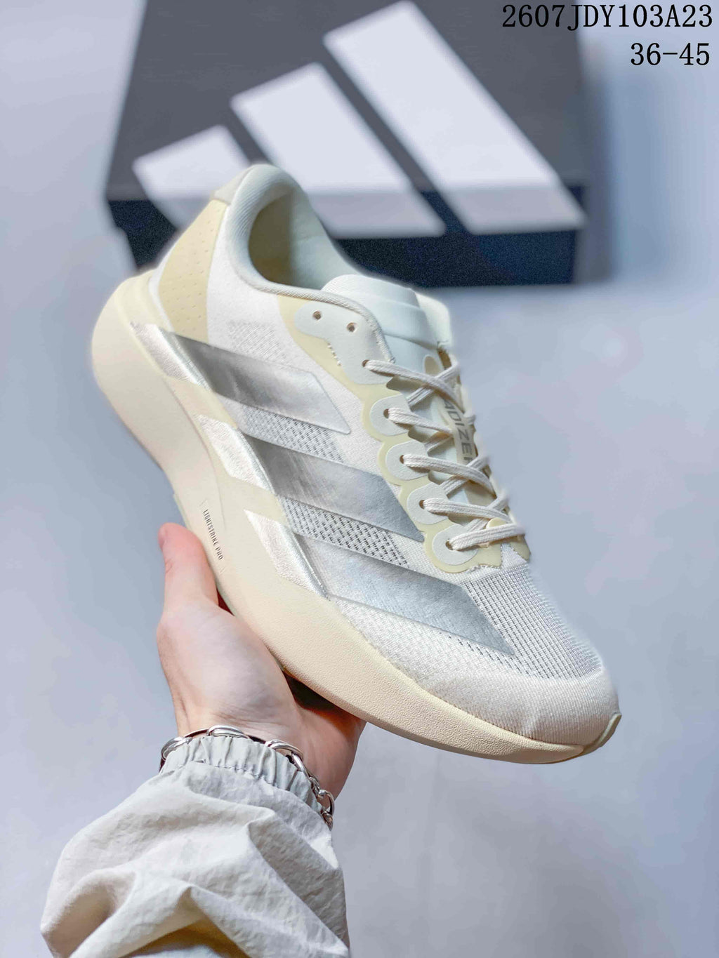Angled side view of the off-white sneaker showing the silver side stripes, lace eyelets and sculpted sole.