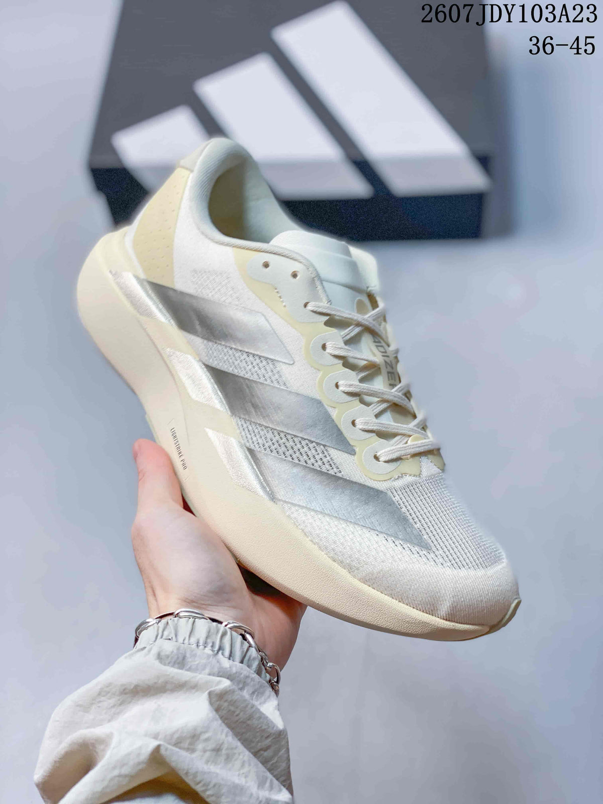 Angled side view of the off-white sneaker showing the silver side stripes, lace eyelets and sculpted sole.