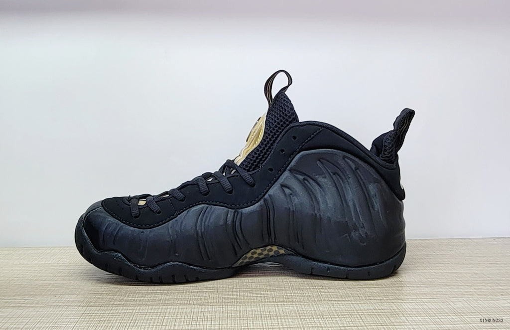 Side profile of a black Nike Air Foamposite Pro sneaker with sculpted panels