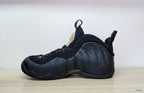 Side profile of a black Nike Air Foamposite Pro sneaker with sculpted panels