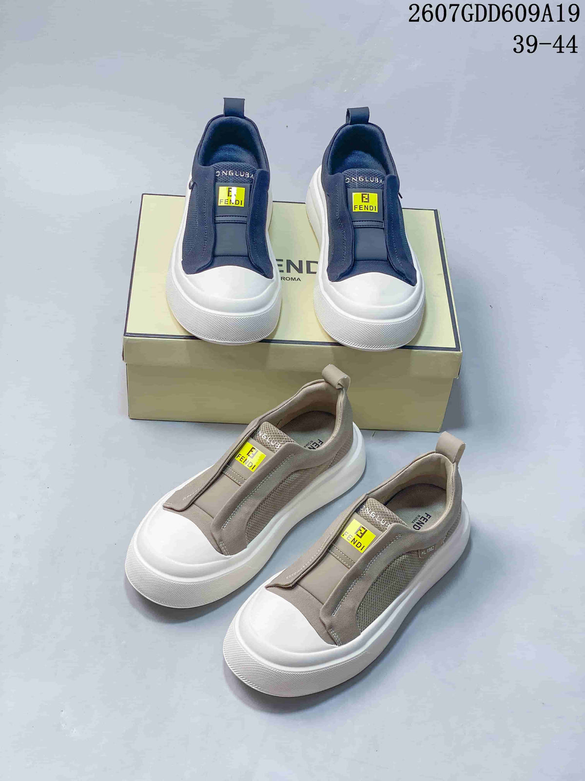 Navy and taupe Fendi slip-on sneakers shown together from above and at an angle, with logo patches and white soles visible; image text lists style code 2607GDD609A19 and sizes 39–44.