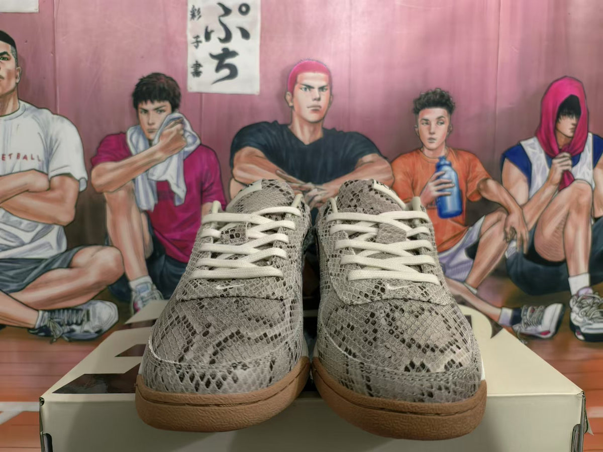 Front view of gray snakeskin-style patterned sneakers with light laces and gum-colored outsoles.