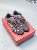 Pair of brown Puma Catch Soleil SD low-top sneakers displayed on a red shoebox, showing white side branding and dark outsoles.