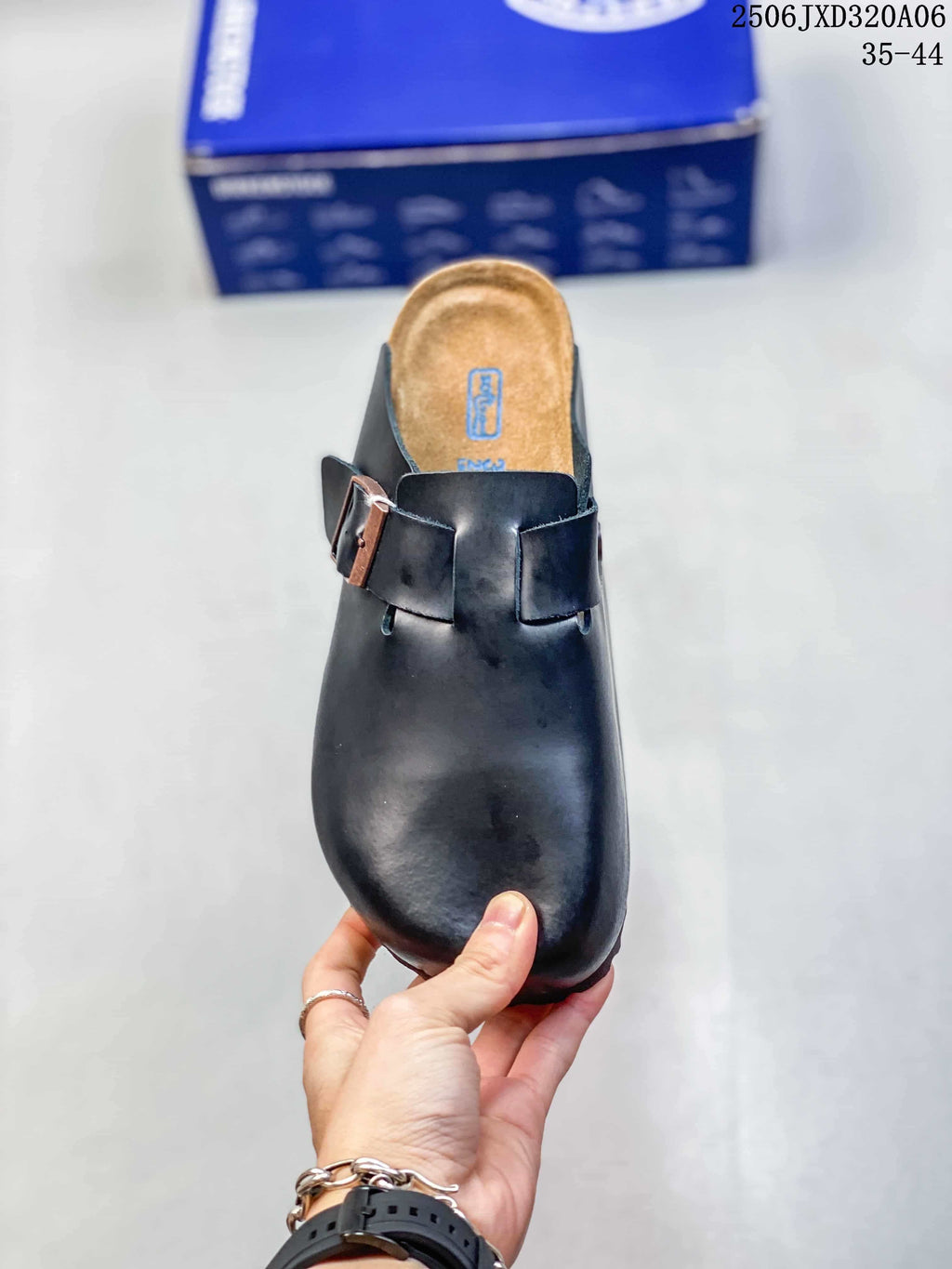 Top view of a black clog showing the rounded closed toe, twin buckle straps, and contoured footbed.