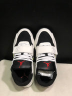 Top view showing white laces, wide midfoot straps, black toe panels, and red tongue branding.