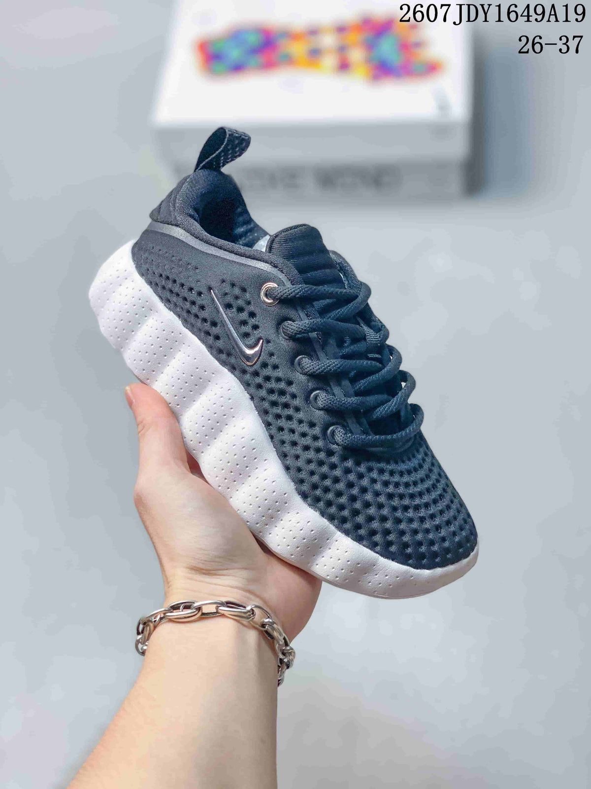 Black and white Nike Mind 002 kids sneaker with a perforated upper and contrast sole.
