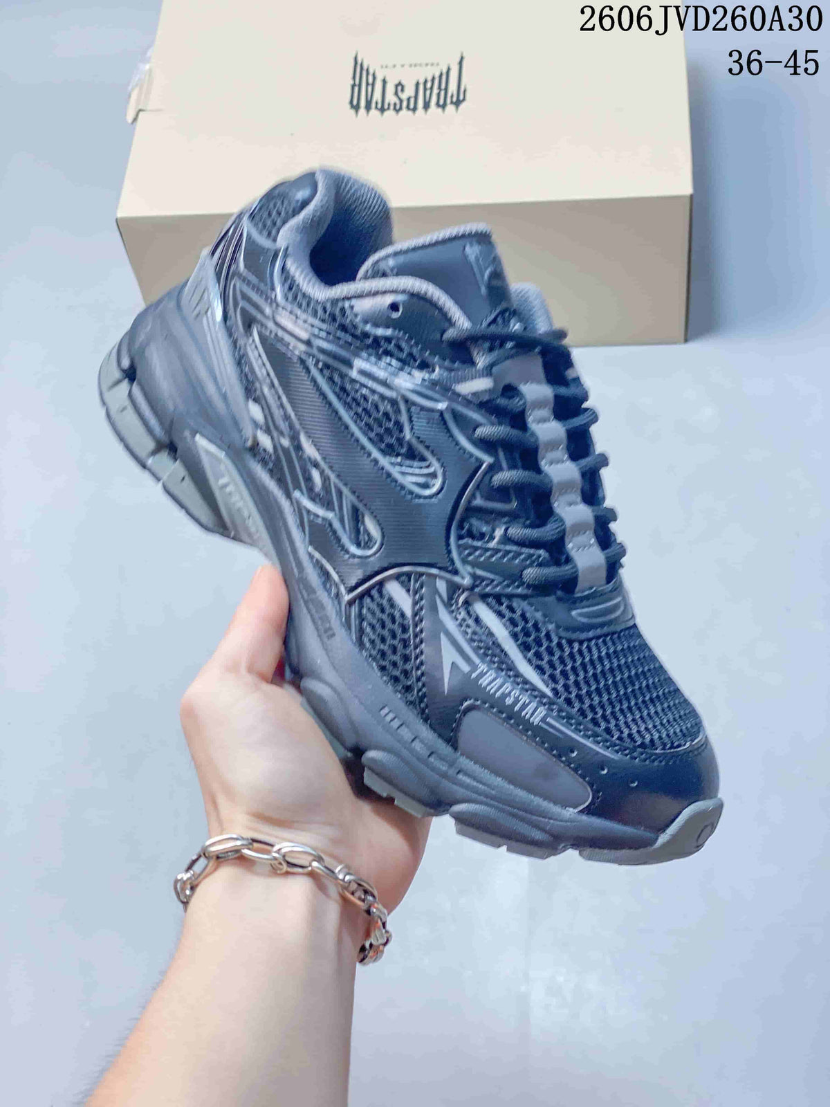 Angled side view of a dark gray sneaker with layered details and a chunky sole