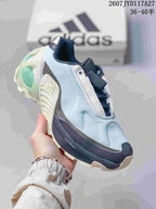 Angled side view showing the pale blue upper, navy midsole, cream outsole and visible ADIPRENE+ marking.