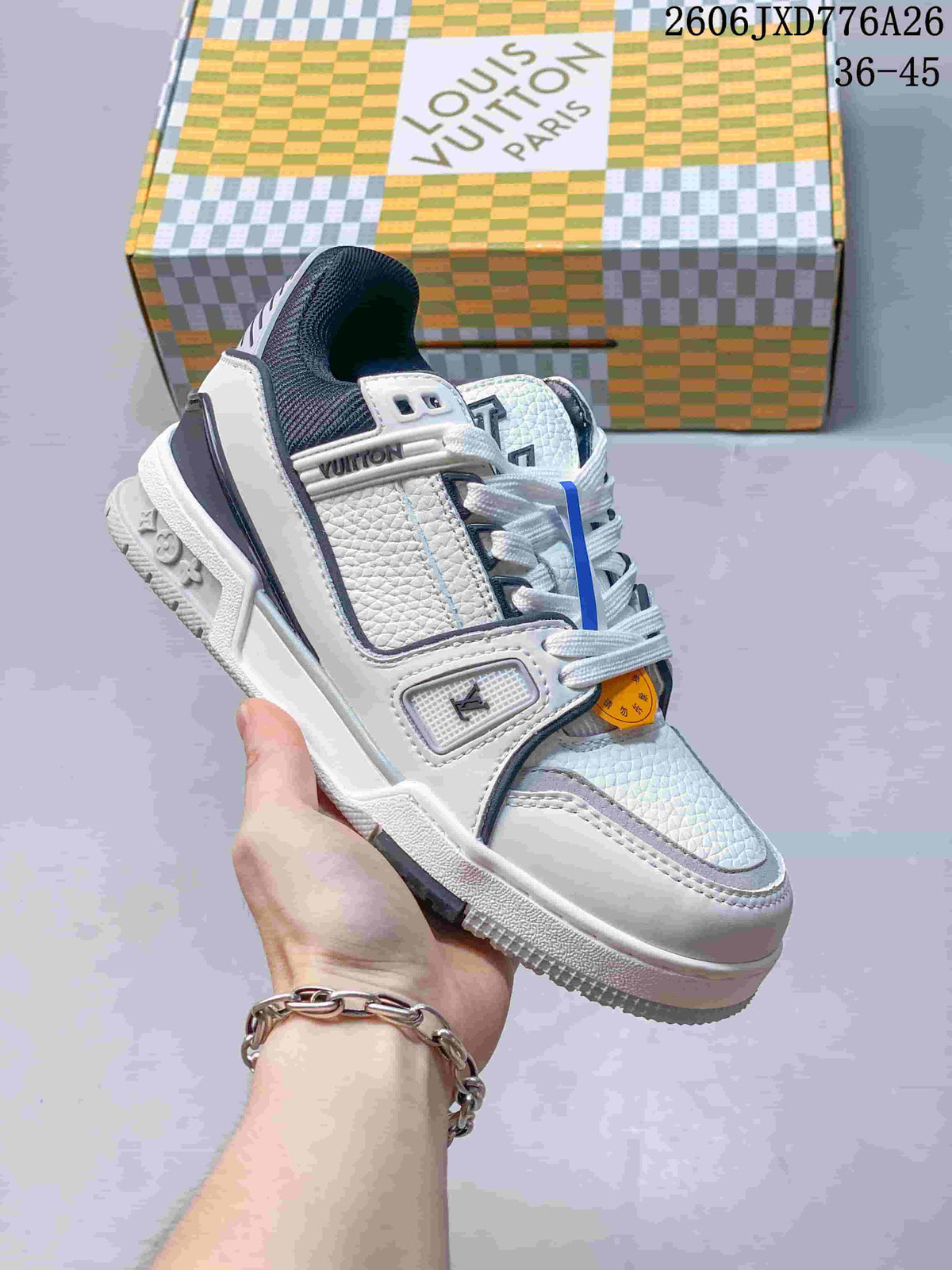 White low-top sneaker with gray and dark accents, shown beside a patterned box