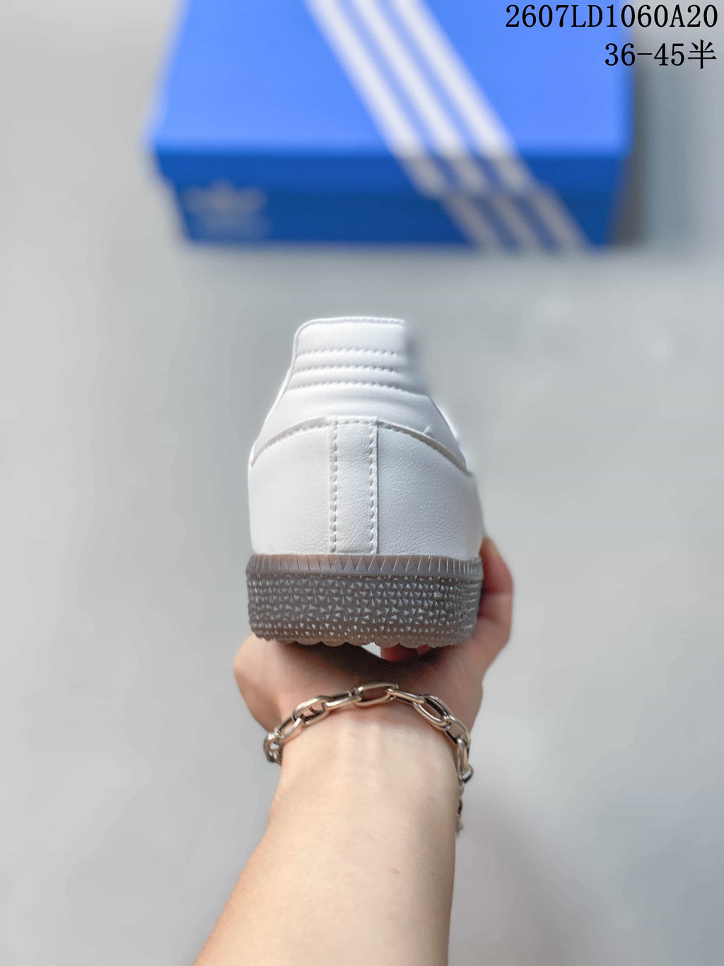 Rear view of the white sneaker showing the heel construction and textured gum-colored outsole.