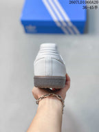 Rear view of the white sneaker showing the heel construction and textured gum-colored outsole.