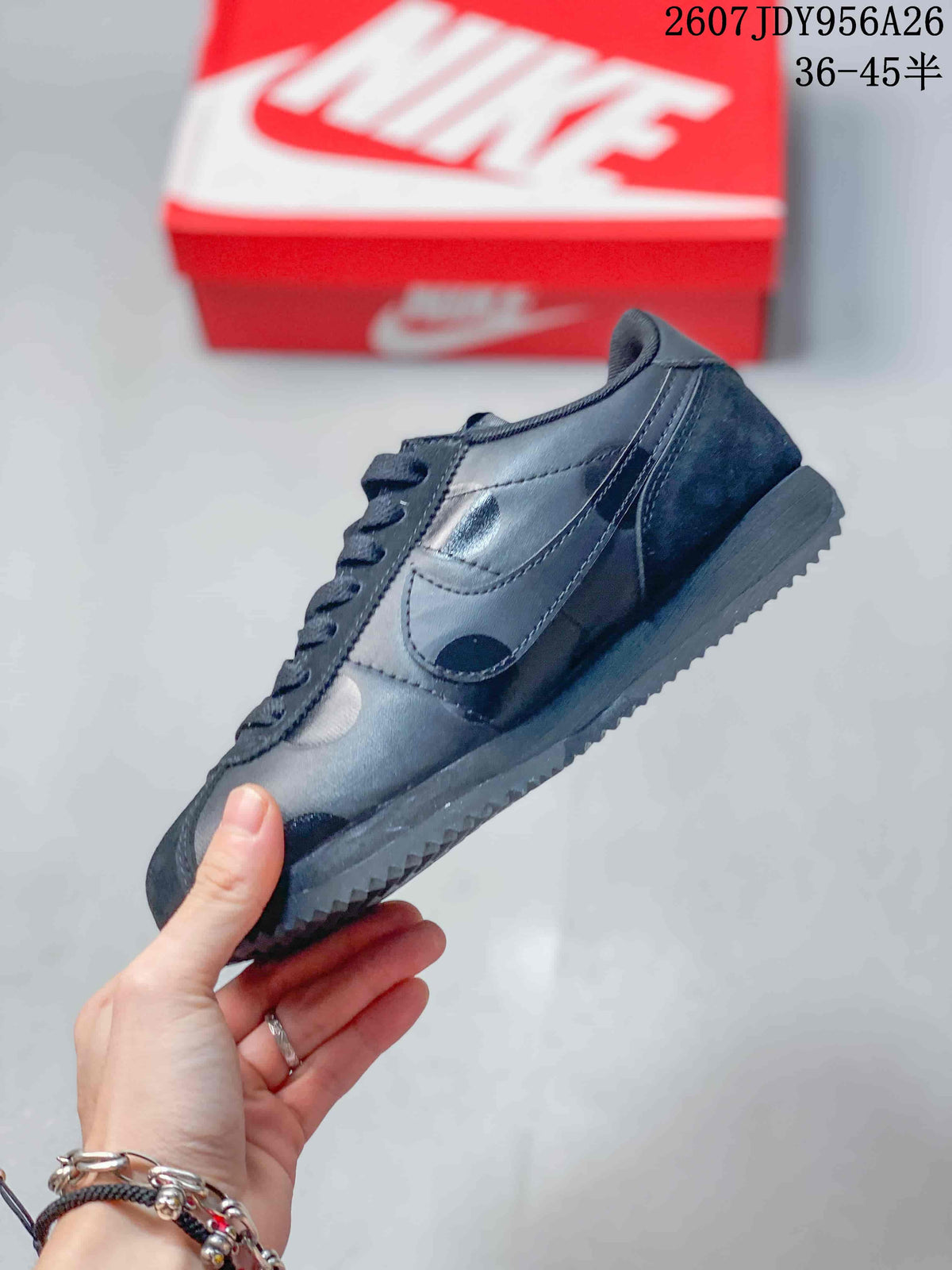 Side view of the black sneaker showing the Swoosh, stitched panels, padded collar, and textured outsole.