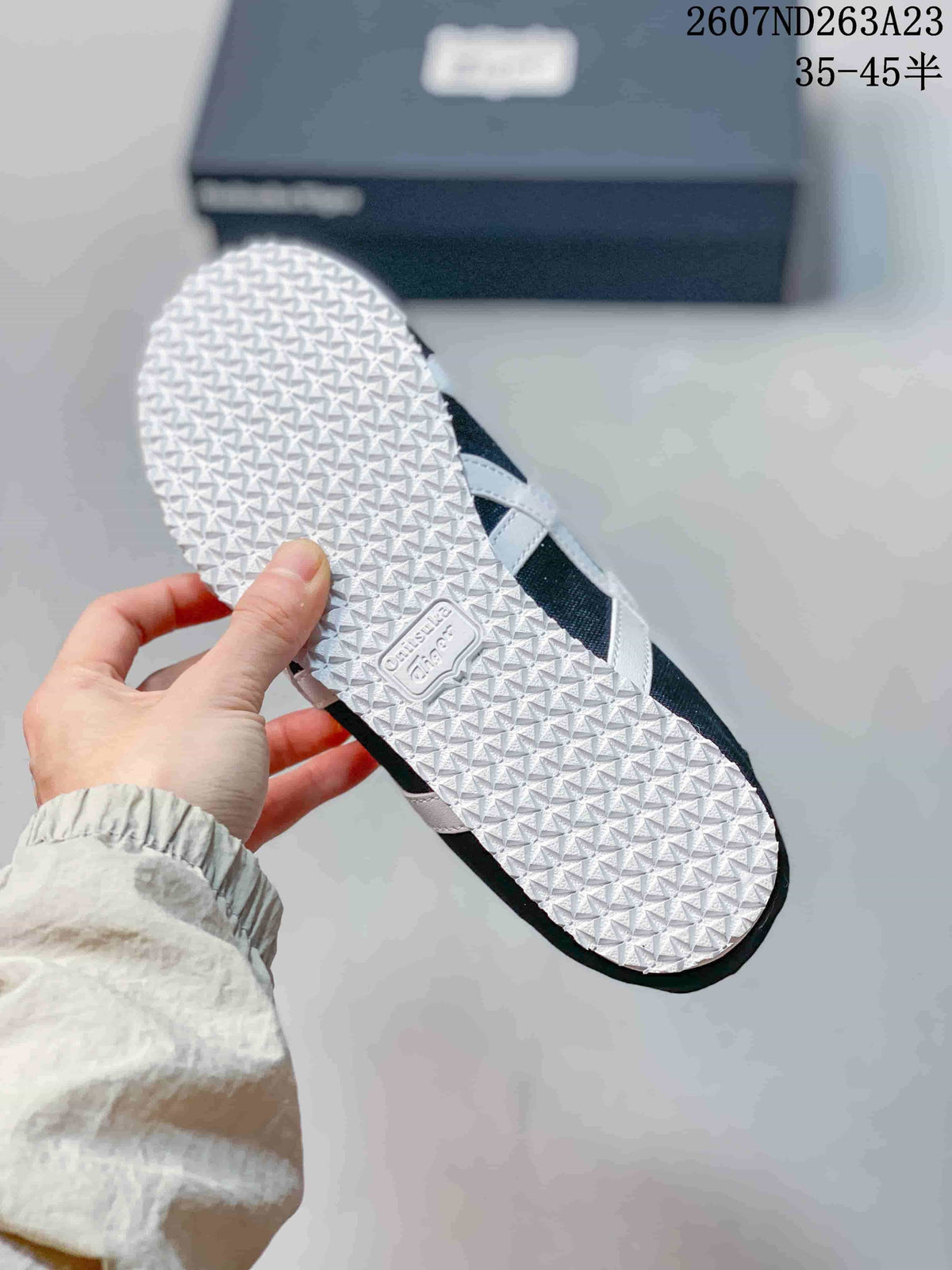 Bottom view of the sneaker showing the white textured outsole and branded sole insert.