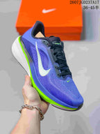 Angled side view of a purple and blue Nike Air Zoom Pegasus 42 shoe with a white Swoosh, black laces, and layered white and bright green sole.