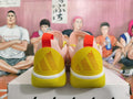 Rear view of pink and yellow basketball sneakers with red heel pull tabs