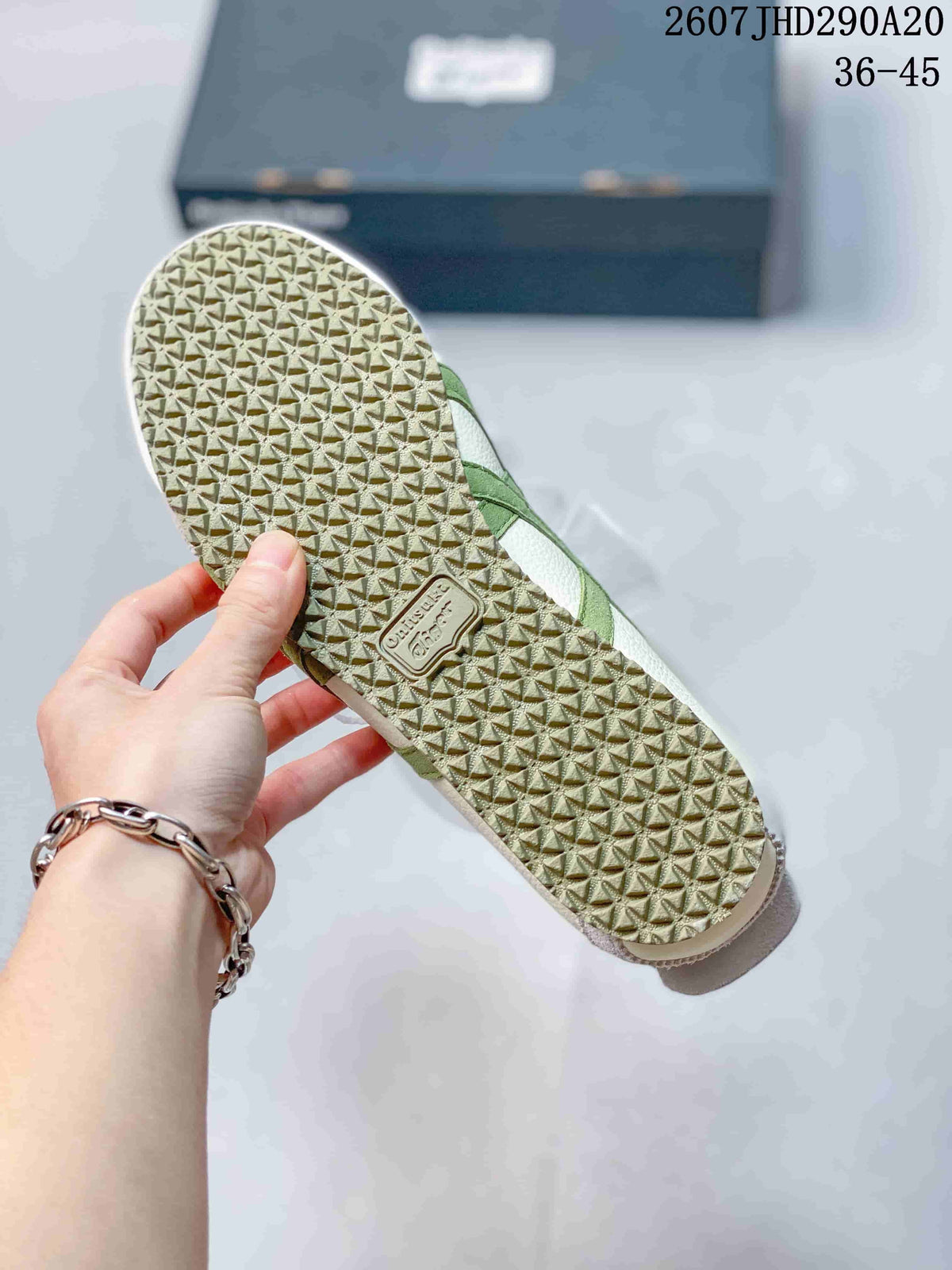 Close-up of the textured light-colored outsole with a repeating geometric tread pattern.