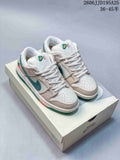 Pair of white Nike SB Dunk Low sneakers with green, orange, and khaki accents displayed on a shoebox; style code JD195A25 and size range 36–45 are overlaid in the image.