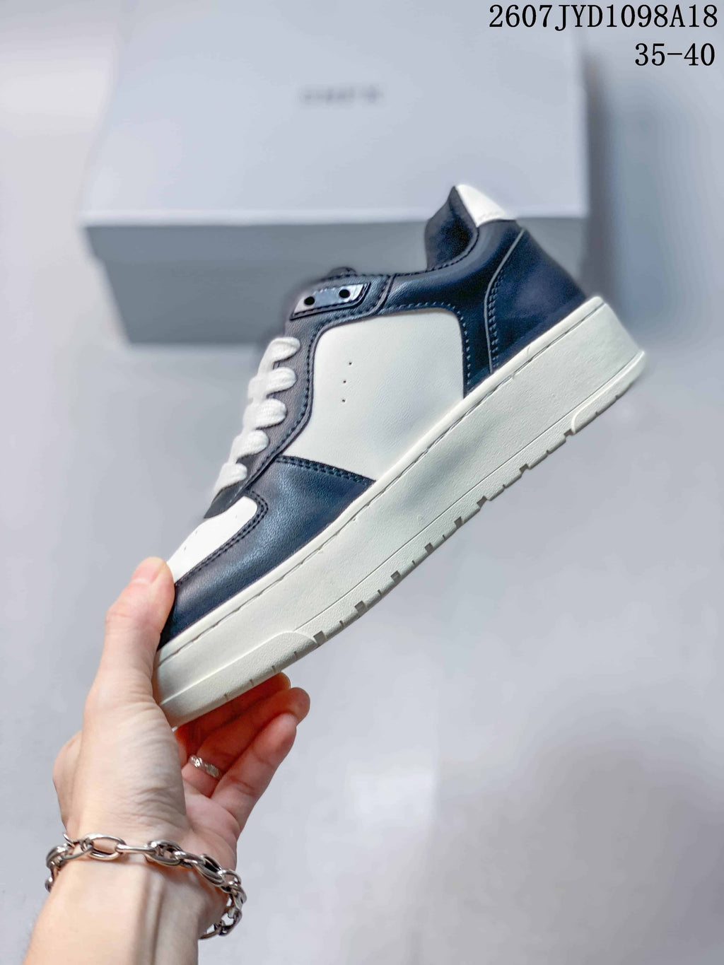Side view showing the navy and white panelled upper and white midsole