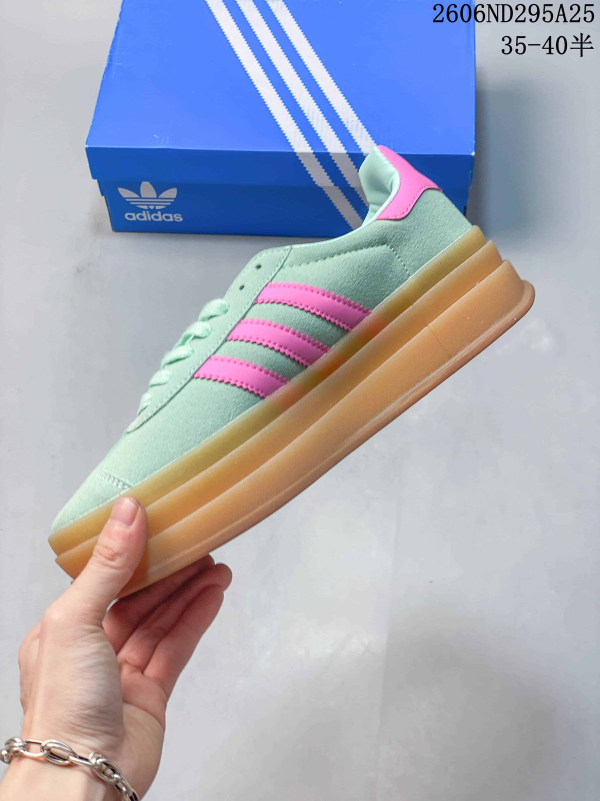 Side profile showing the mint green upper, pink three-stripe details, and raised gum platform sole.
