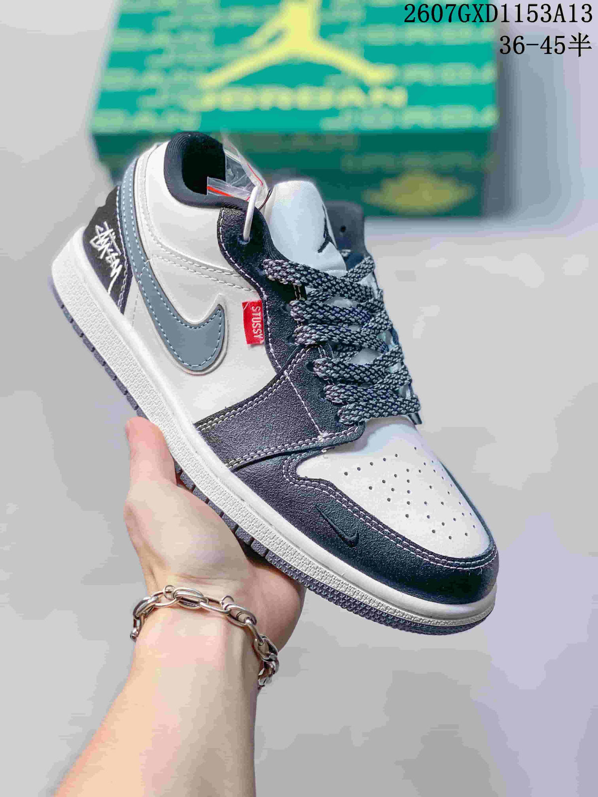 Angled close-up showing the grey Swoosh, contrasting upper panels, red side tag and lace accessories.