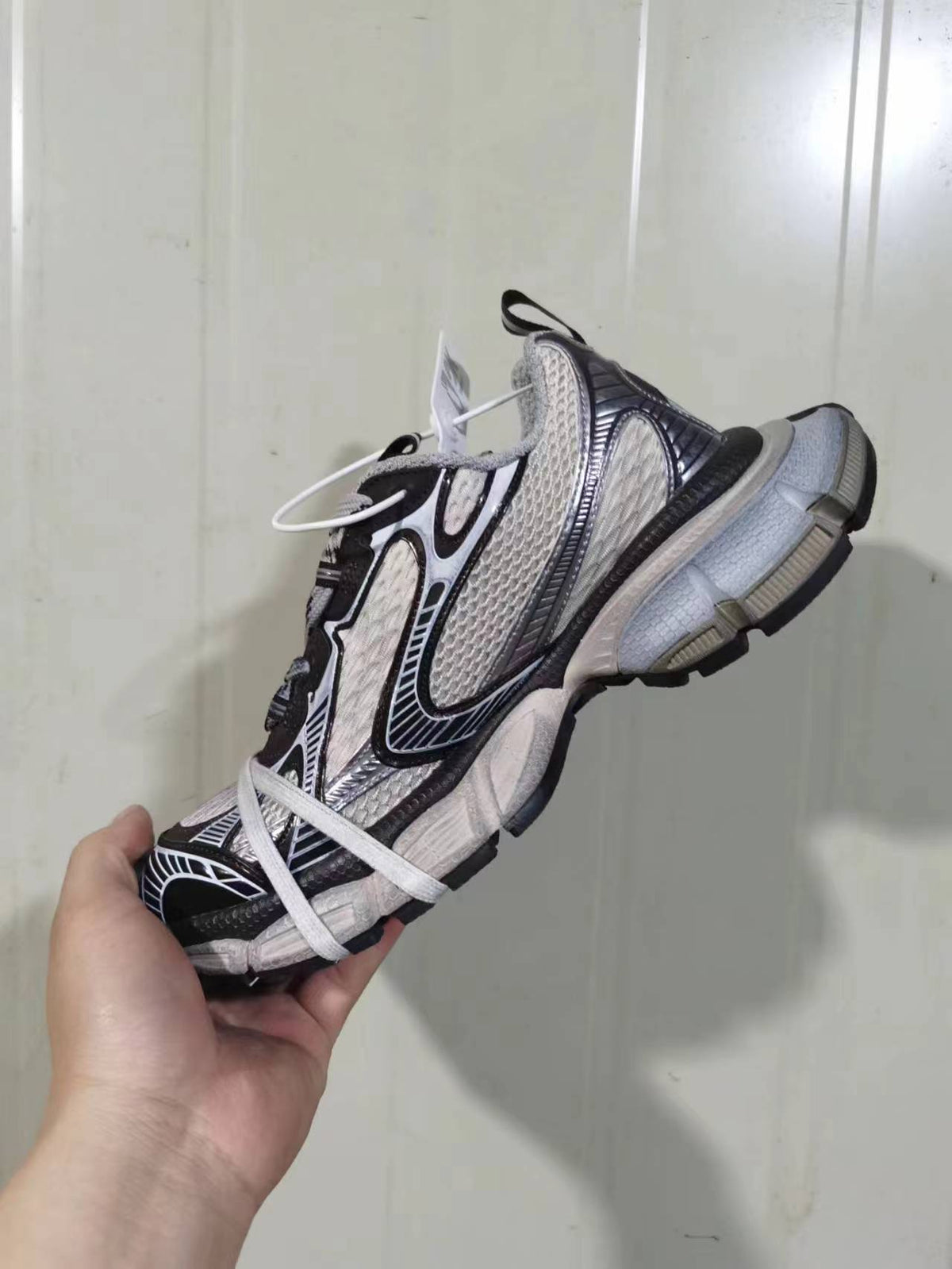 Side and heel view of the sneaker showing the layered upper, padded heel area, contrasting trim, and segmented outsole.