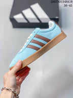 Side profile showing the light blue upper, brown side stripes, cream laces, and low gum-colored sole.