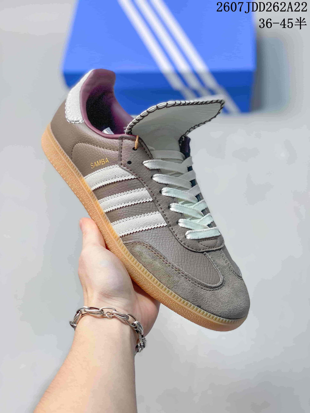 Angled side view showing Samba branding, white stripes, gray panels, and gum outsole.