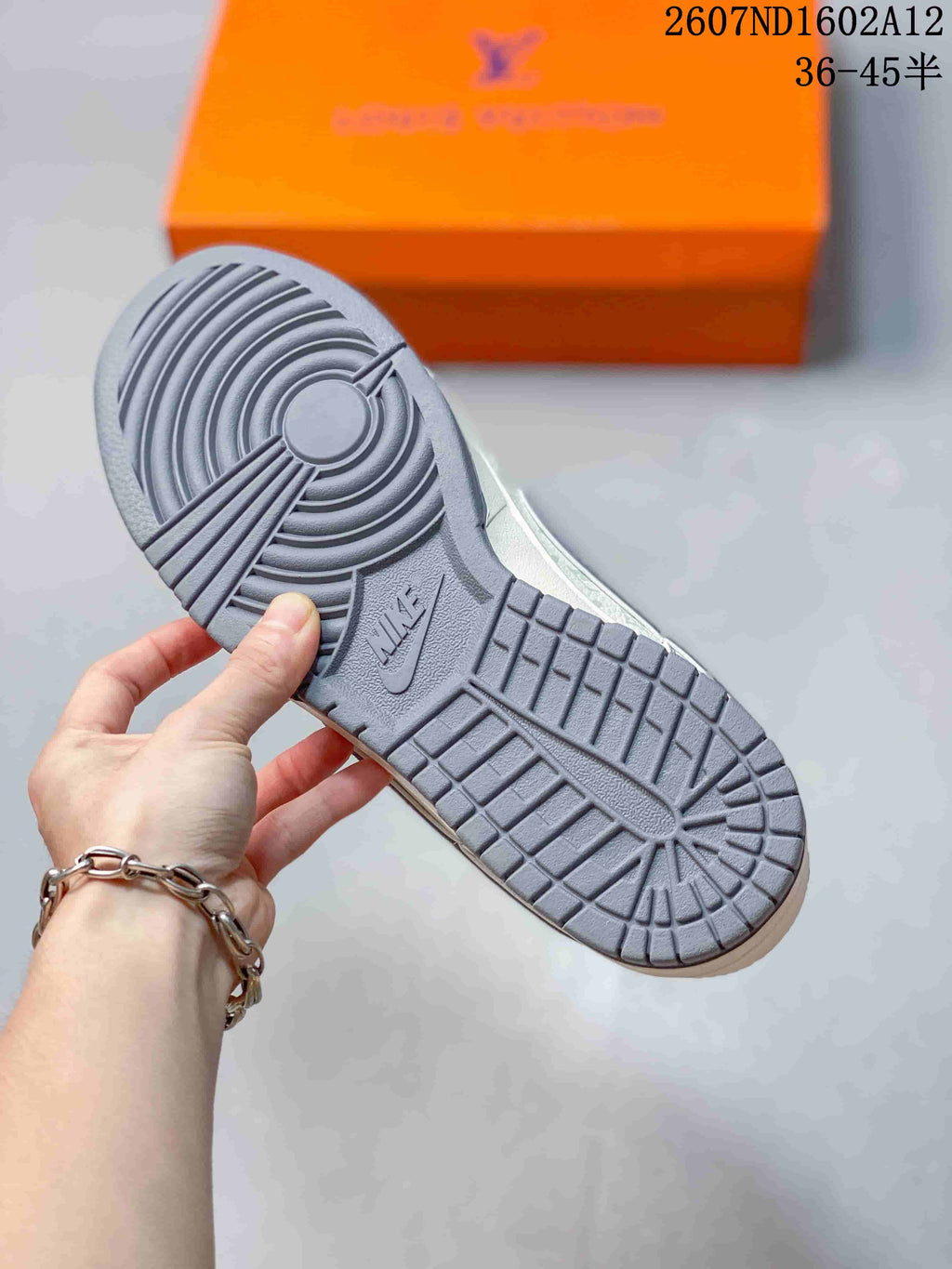 Close view of the gray rubber outsole showing concentric circular traction at the forefoot and heel with a grid pattern through the center.