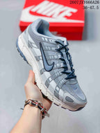 Angled side view of a gray and white Nike P-6000 sneaker showing the retro running-inspired upper and segmented sole.