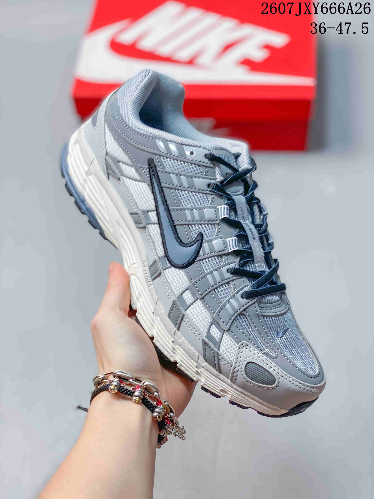 Angled side view of a gray and white Nike P-6000 sneaker showing the retro running-inspired upper and segmented sole.