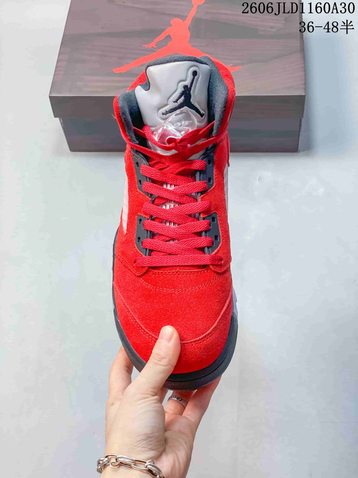 Front view of the red sneaker with dark lace hardware and a padded tongue.